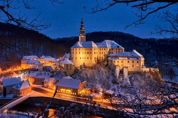 Schloss Weesenstein beleuchtet im Winter bei Abenddämmerung.