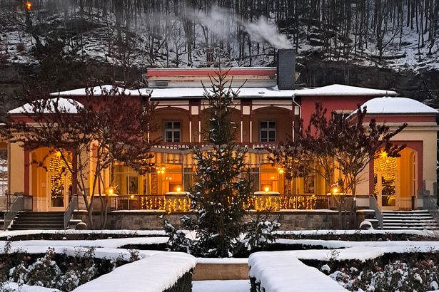 Historisches Gebäude umgeben von winterlichem Wald.
