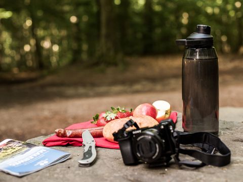 Kamera und Trinkflasche auf einem Stein