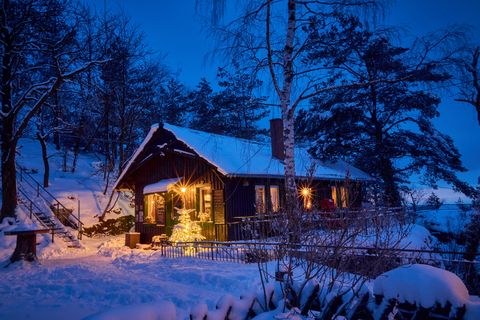 Beleuchtete Baude in Abenddämmerung im Winter.