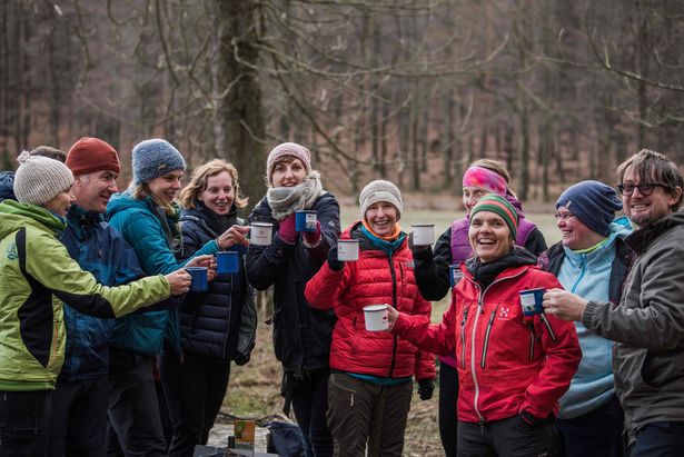 Winterwanderung mit Glühweinkochen Personengruppe stößt zusammen an.