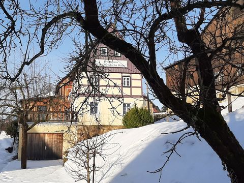 Verschneites Ferienhaus im Wald.