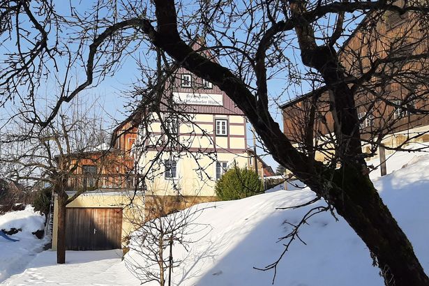 Verschneites Ferienhaus im Wald.