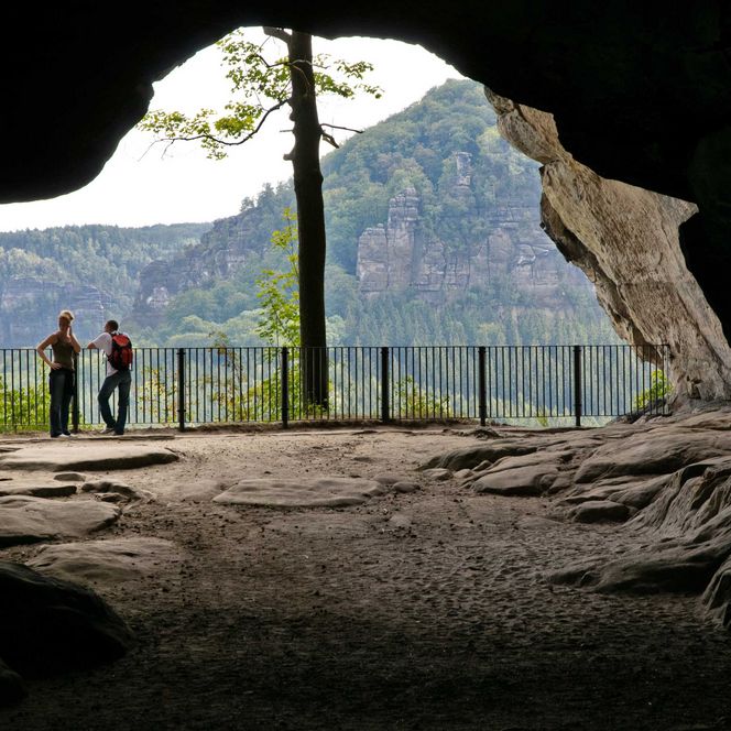 Blick durch eine Felsentor, genannt Kuhstall auf Wald und Felslandschaft