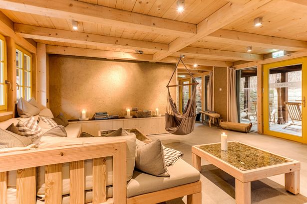Ruheraum aus Holz mit Sessel und Baenken.