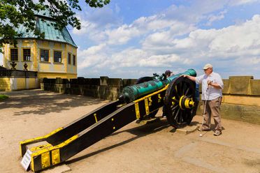 Mann in weißem Hut betrachtet große Kanone neben dem Friedrichschlößchen der Festung Königstein.