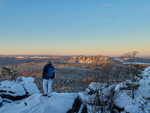 Person überblickt nebelige Berglandschaft von Aussichtspunkt.