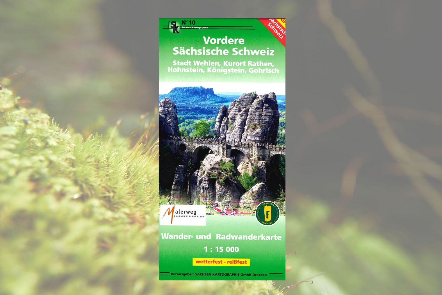Wanderkarte mit grüner Umrandung und Foto von Basteibrücke umgeben von Felsen und Wald.
