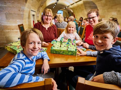 Kinder spielen historische Spiele auf einer Festung.