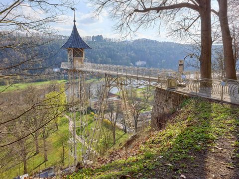 Alter Personenaufzug in Bad Schandau, grauer Turm, üppige grüne Umgebung.