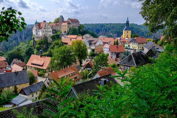 Hohnstein mit Burg, umgeben von grünen dichten Wäldern.