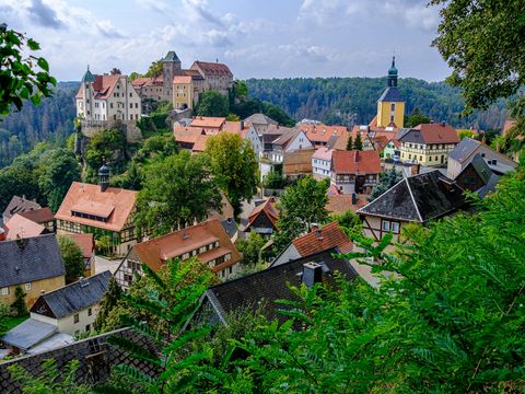Hohnstein mit Burg, umgeben von grünen dichten Wäldern.