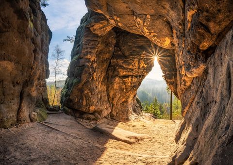 Sonnenstrahlen scheinen durch eine Felsöffnung der Kleinsteinhöhle.