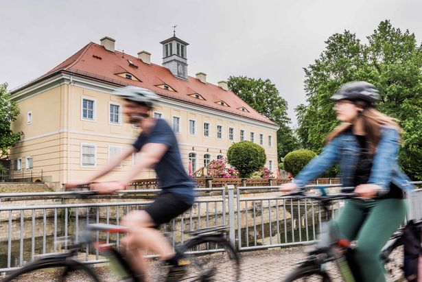Zwei Radfahrer unterwegs auf der Mittellandroute am Jagdschloss Graupa bei Pirna