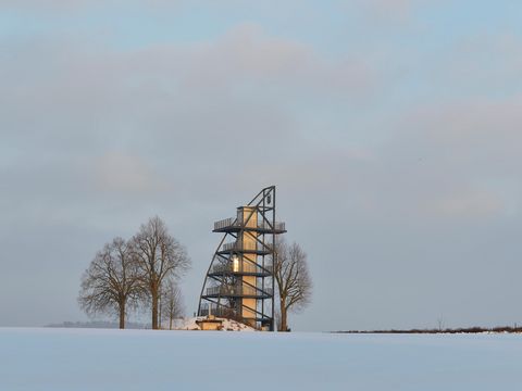 Aussichtsturm auf Rathmannsdorfer Höhe, im Vordergrund schneebedeckte Wiese.
