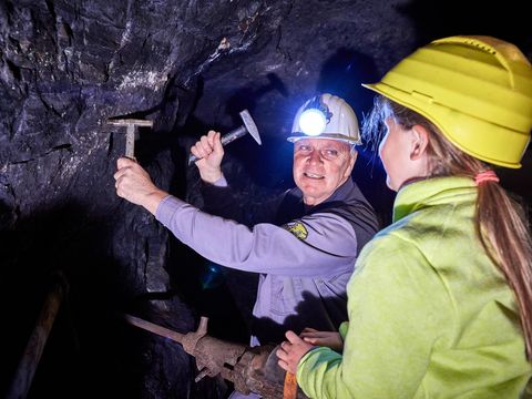Kinderführung im Besucherbergwerk "Marie Louise Stolln" Kindergruppe mit Helmen erkundet unterirdisches Bergwerk.