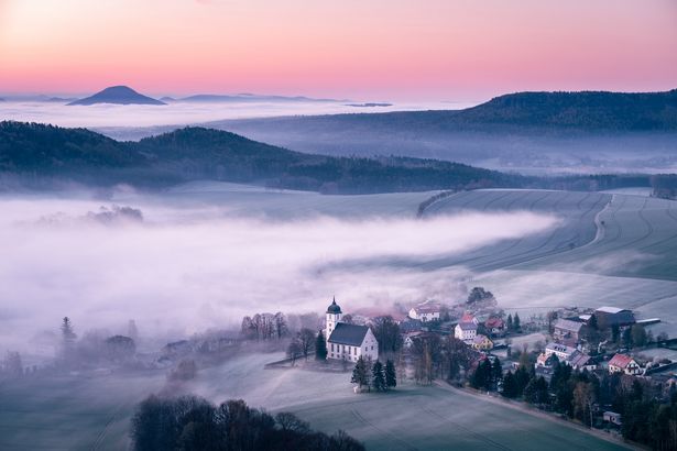 Sonnenaufgang über bewaldeten Hügeln, Blick von Papststein zu Papstdorf.