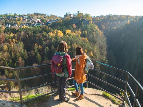 Zwei Frauen stehen an Geländer und Blicken auf Burg Hohnstein.