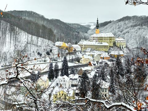 Schloss umgeben von Schnee, klare Sicht, blauer Himmel.