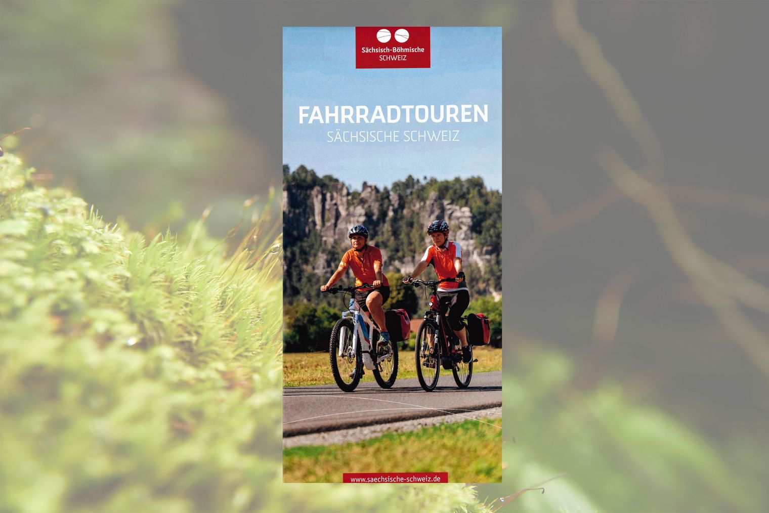 Titelbild: zwei Frauen mit Helm fahren mit Fahrrad entlang der Elbe