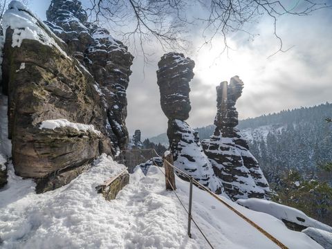 Verschneite Felsen im Wald, blauer Himmel, Sonnenschein.
