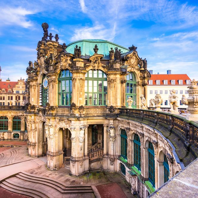 Dresdner Zwinger mit barocker Architektur, blauer Himmel und Wolken im Hintergrund.