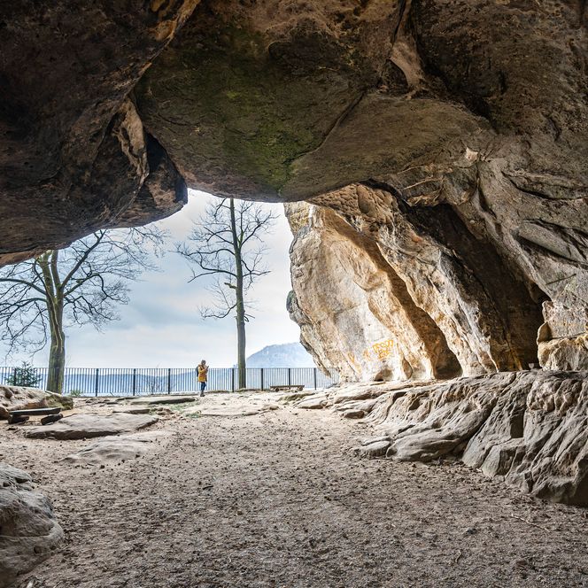 Blick durch eine Felsentor, genannt Kuhstall auf Wald und Felslandschaft