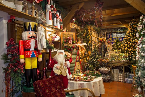 Weihnachtlich dekoriertes Zimmer mit beleuchtetem Baum und Geschenken.