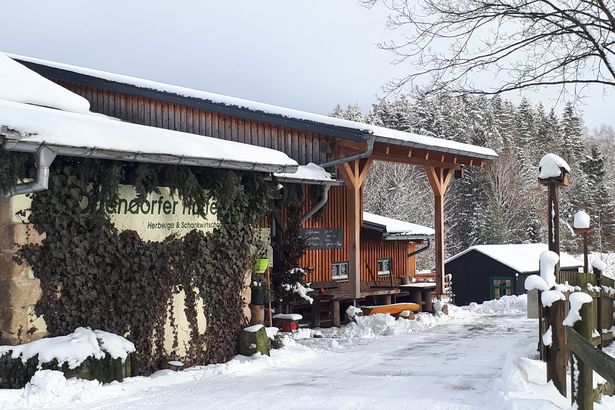Verschneite Hütte im Wald.